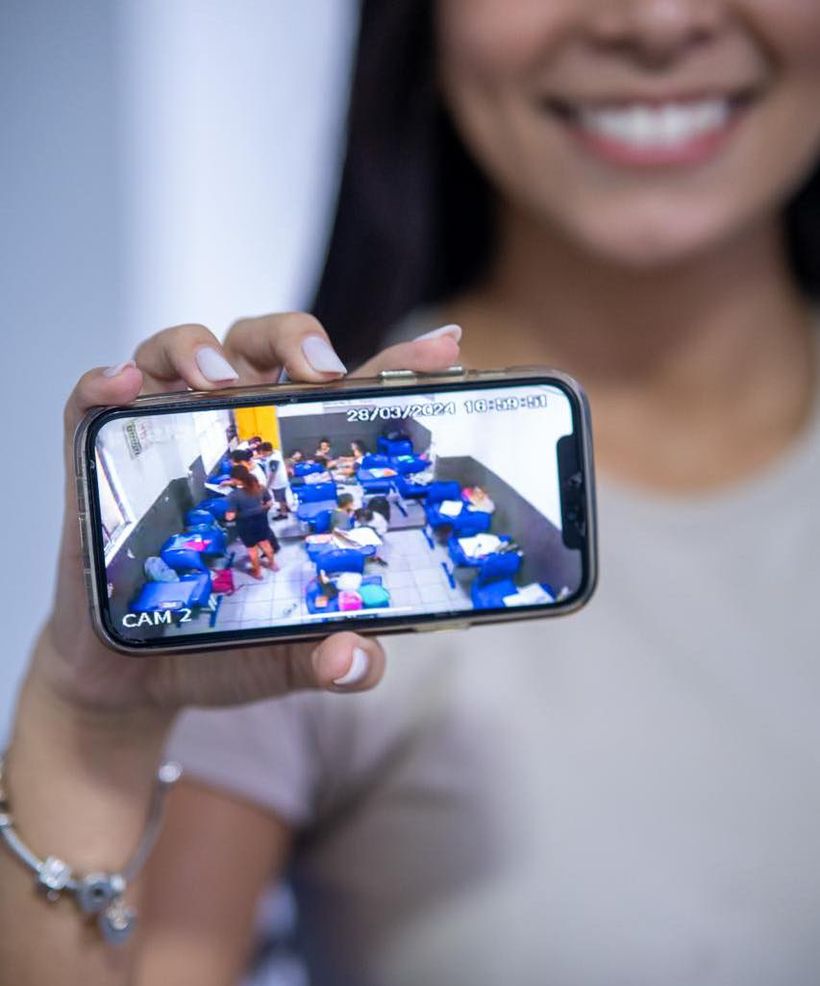 Mãe de aluno do Colégio Crer&Ser acompanhando a sala de aula do filho ao vivo pelo celular