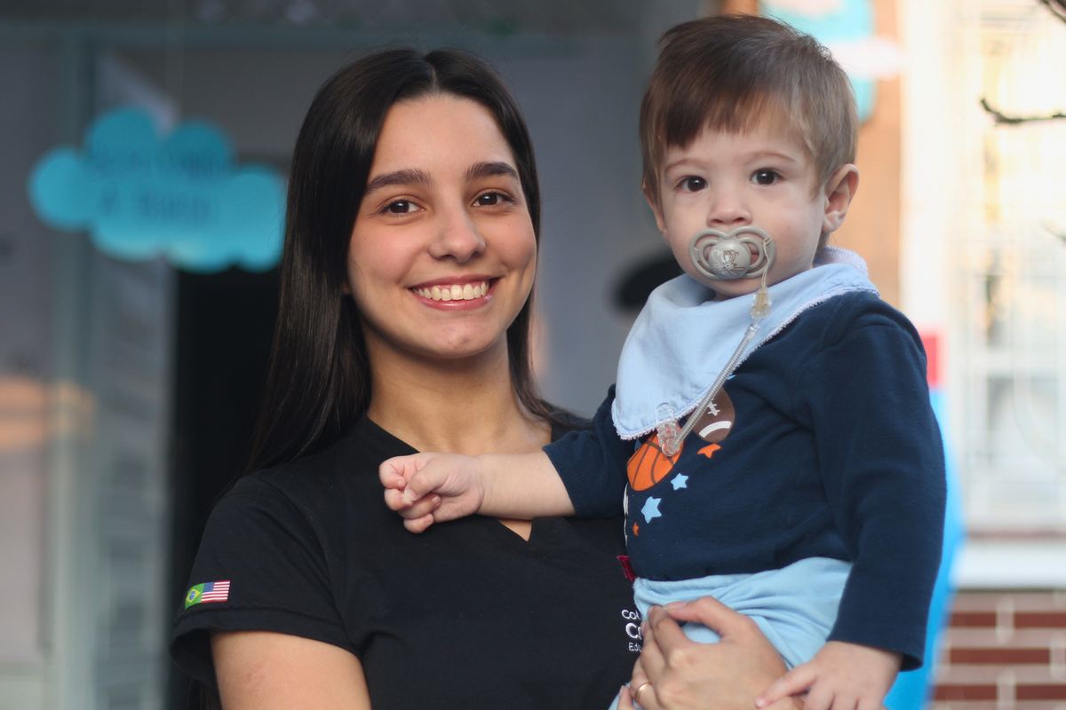 Professora do Colégio Crer&Ser no colo com bebê do berçário